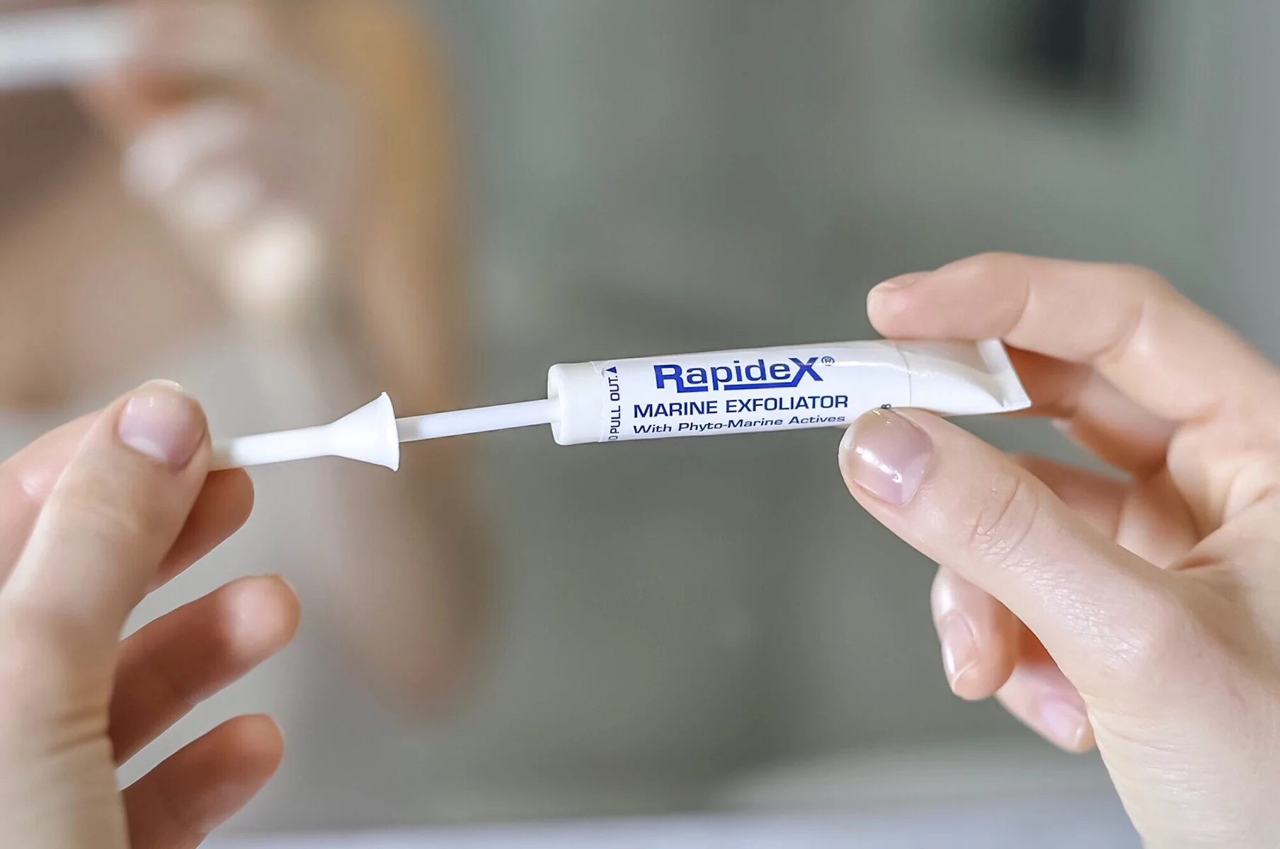 Käsi pitelee Repechage Rapidex Marine Exfoliator -kuorintatuotetta, jossa on Fyto-Marine Actives -yhdistelmä.